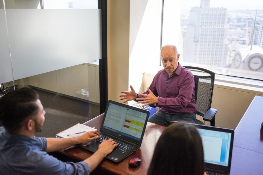 a man and woman sitting at a table with laptops