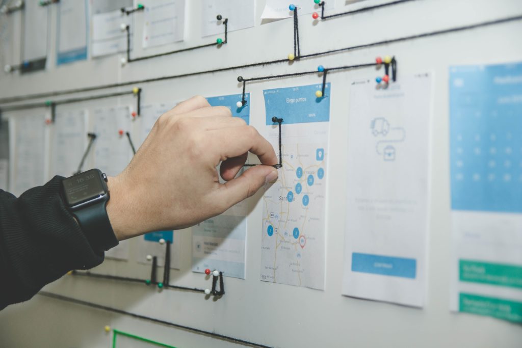 A person pushing a pin into a posterboard