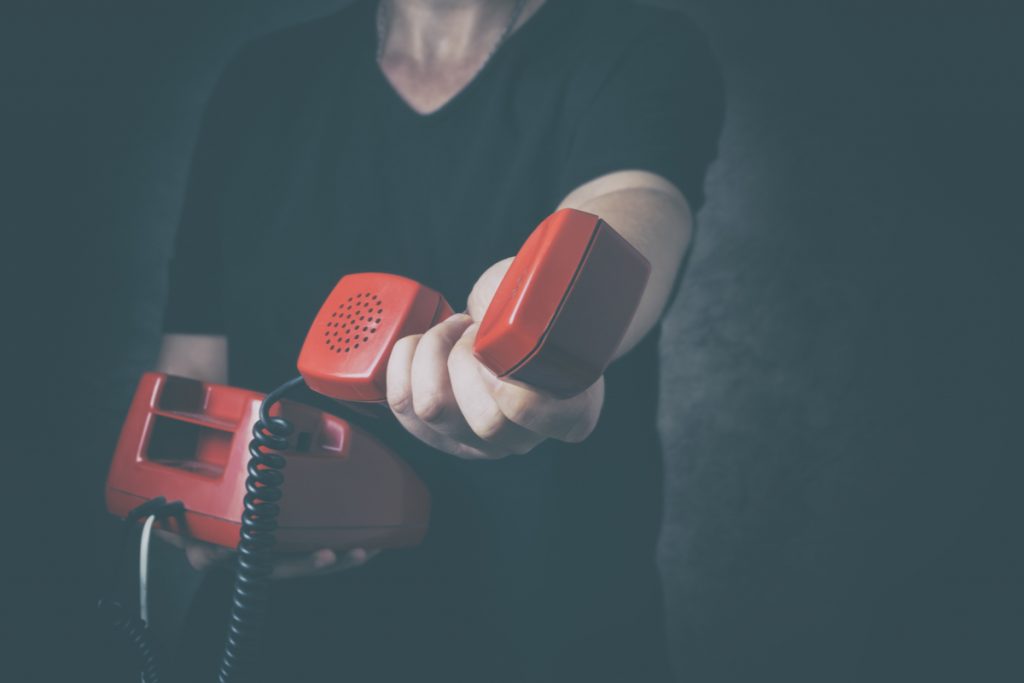 a person holding a red telephone
