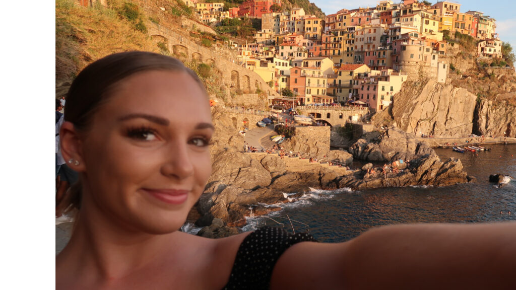 a woman taking a selfie with a city in the background